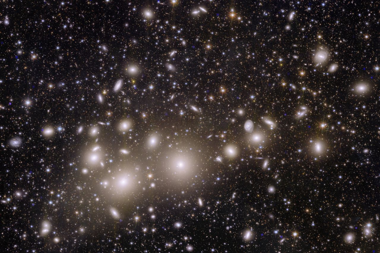 Imagem astronômica mostrando milhares de galáxias na extensão negra do espaço.  As cerca de mil galáxias mais próximas pertencem ao Aglomerado de Perseu. 